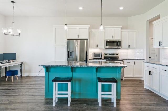 2316 Dixie Dr, Blanchard, OK 73010 - kitchen featuring appliances with stainless steel finishes, decorative backsplash, dark wood-style floors, a kitchen island, and recessed lighting