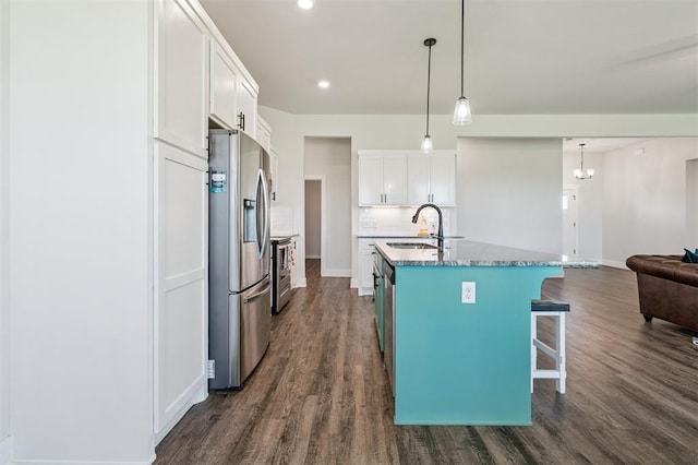 2316 Dixie Dr, Blanchard, OK 73010 - kitchen with appliances with stainless steel finishes, dark wood-type flooring, white cabinetry, a breakfast bar, and recessed lighting