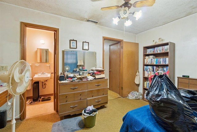 720 NW 16th St, Moore, OK 73160 - bedroom with light carpet, a textured ceiling, ensuite bath, and a ceiling fan