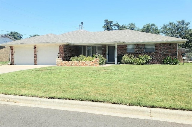 1008 E Hughes St, Blair, OK 73526 - ranch-style home with a front lawn, a garage, driveway, and brick siding