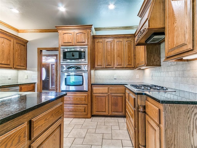 4813 SE 28th St, Oklahoma City, OK 73165 - kitchen with stainless steel appliances, custom range hood, brown cabinets, crown molding, and backsplash