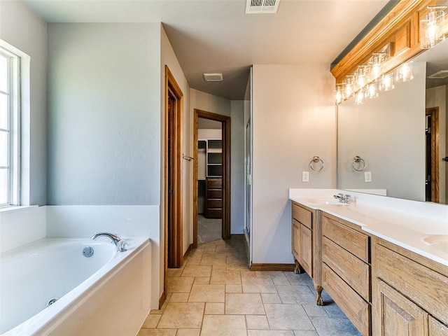 4813 SE 28th St, Oklahoma City, OK 73165 - bathroom with double vanity, stone finish floors, a bath, and healthy amount of natural light