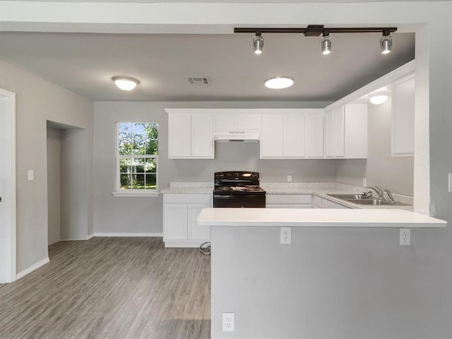 3927 SE 10th Pl, Del City, OK 73115 - kitchen featuring black electric range oven, under cabinet range hood, light countertops, and white cabinetry