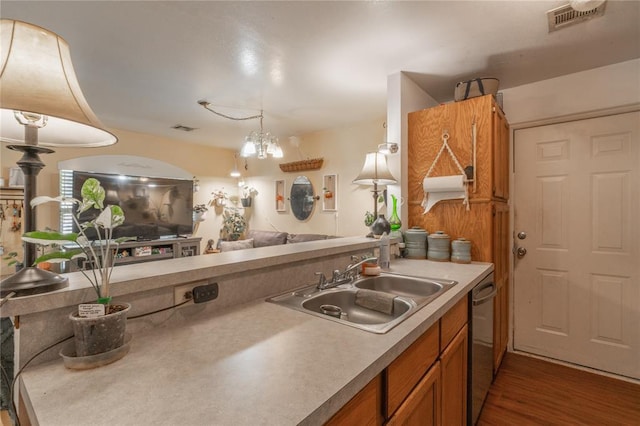 957 N Windermere Dr, Moore, OK 73160 - kitchen featuring dishwasher, brown cabinetry, open floor plan, light countertops, and hanging light fixtures