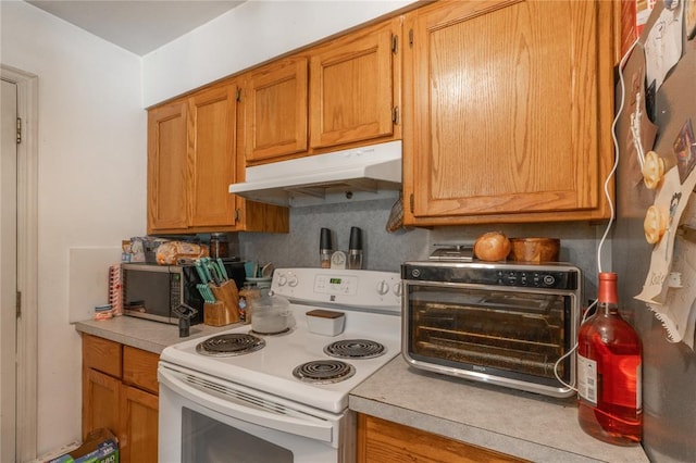 957 N Windermere Dr, Moore, OK 73160 - kitchen with white range with electric cooktop, under cabinet range hood, light countertops, and brown cabinetry