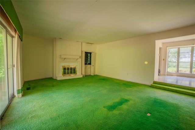 1507 Mill Creek Rd, Edmond, OK 73025 - unfurnished living room with a glass covered fireplace and carpet flooring