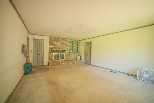 1507 Mill Creek Rd, Edmond, OK 73025 - unfurnished living room featuring light colored carpet and a brick fireplace