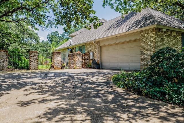 1507 Mill Creek Rd, Edmond, OK 73025 - view of property exterior with driveway, brick siding, and an attached garage