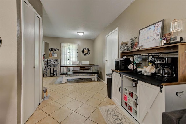 625 N Ramblin Oaks Dr, Moore, OK 73160 - kitchen with dark countertops, light tile patterned floors, black microwave, and white cabinets