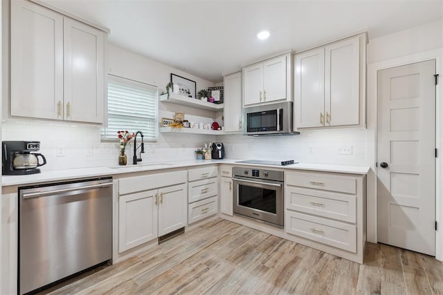 8 Corona Dr, Oklahoma City, OK 73149 - kitchen with stainless steel appliances, tasteful backsplash, light countertops, light wood-style floors, and recessed lighting