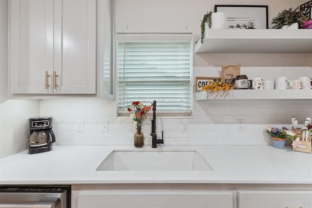8 Corona Dr, Oklahoma City, OK 73149 - kitchen featuring stainless steel dishwasher, light countertops, tasteful backsplash, and white cabinetry