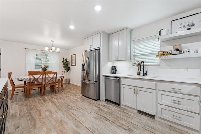 8 Corona Dr, Oklahoma City, OK 73149 - kitchen with appliances with stainless steel finishes, light countertops, a chandelier, light wood finished floors, and recessed lighting