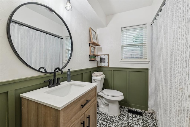 8 Corona Dr, Oklahoma City, OK 73149 - bathroom featuring vanity, a decorative wall, wainscoting, and tile patterned flooring