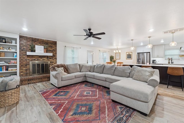 8 Corona Dr, Oklahoma City, OK 73149 - living area featuring light wood-style flooring, ceiling fan, a fireplace, recessed lighting, and built in features