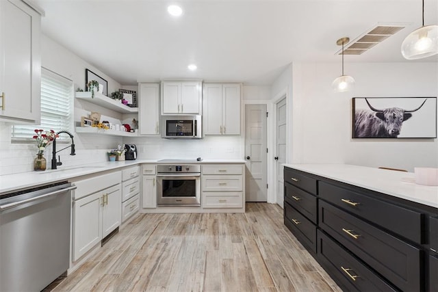 8 Corona Dr, Oklahoma City, OK 73149 - kitchen featuring appliances with stainless steel finishes, tasteful backsplash, white cabinetry, and recessed lighting