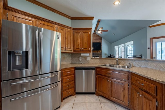 4700 SE 118th St, Oklahoma City, OK 73165 - kitchen featuring appliances with stainless steel finishes, brown cabinets, ceiling fan, decorative backsplash, and light tile patterned flooring