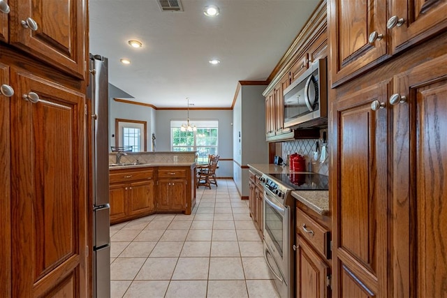 4700 SE 118th St, Oklahoma City, OK 73165 - kitchen featuring appliances with stainless steel finishes, crown molding, brown cabinetry, backsplash, and light tile patterned floors