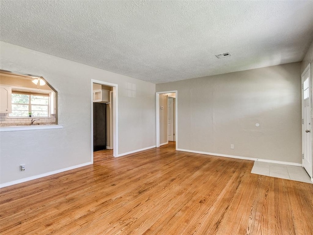 117 Asbill Ave, Yukon, OK 73099 - spare room with a textured ceiling and light wood-style floors