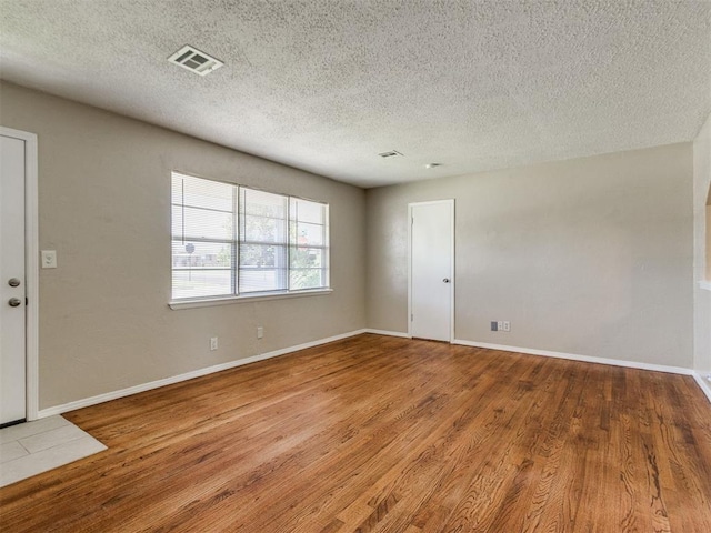 117 Asbill Ave, Yukon, OK 73099 - spare room featuring wood finished floors and a textured ceiling
