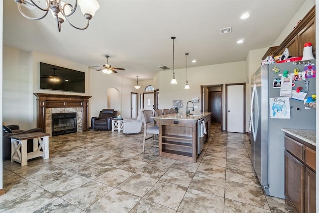 3730 Ruby Rdg, Piedmont, OK 73078 - kitchen featuring freestanding refrigerator, a kitchen island with sink, a chandelier, a tiled fireplace, and open floor plan