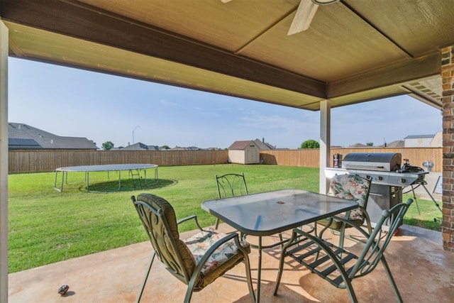 3730 Ruby Rdg, Piedmont, OK 73078 - fenced backyard featuring a storage shed, a trampoline, a patio area, outdoor dining area, and a ceiling fan