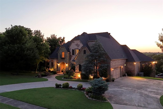 3325 Winding Creek Cir, Edmond, OK 73034 - french provincial home with curved driveway, stone siding, and a yard