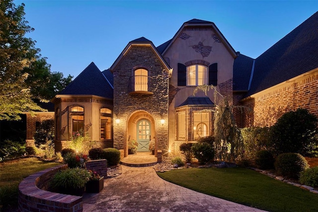3325 Winding Creek Cir, Edmond, OK 73034 - french provincial home featuring stone siding, a front lawn, brick siding, and stucco siding