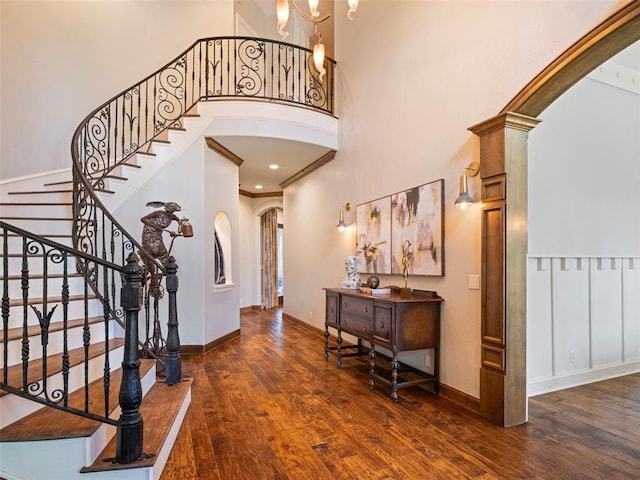 3325 Winding Creek Cir, Edmond, OK 73034 - foyer entrance with arched walkways, a towering ceiling, wood finished floors, and stairs