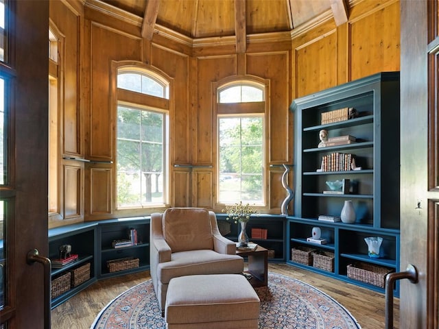 3325 Winding Creek Cir, Edmond, OK 73034 - sitting room with wooden walls, wood finished floors, a wood ceiling with exposed beams, ornamental molding, and a decorative wall