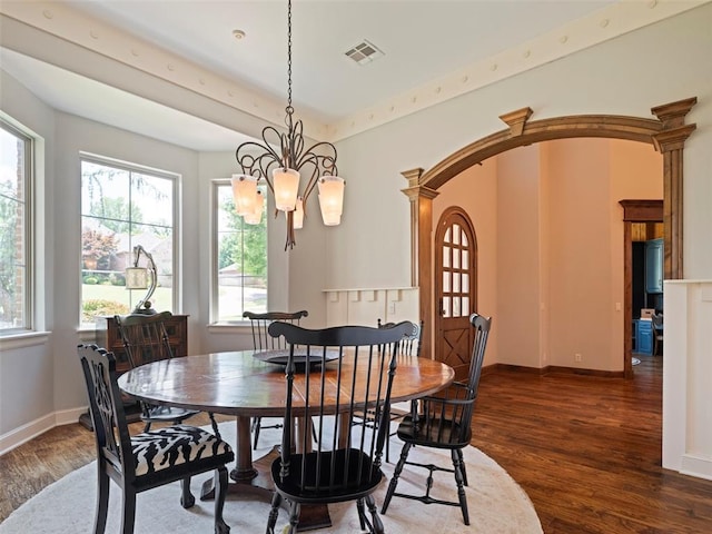 3325 Winding Creek Cir, Edmond, OK 73034 - dining area with wood finished floors, a chandelier, and arched walkways