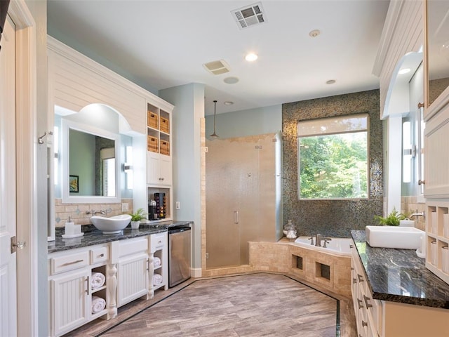 3325 Winding Creek Cir, Edmond, OK 73034 - bathroom featuring a shower stall, vanity, a garden tub, tasteful backsplash, and wood finished floors