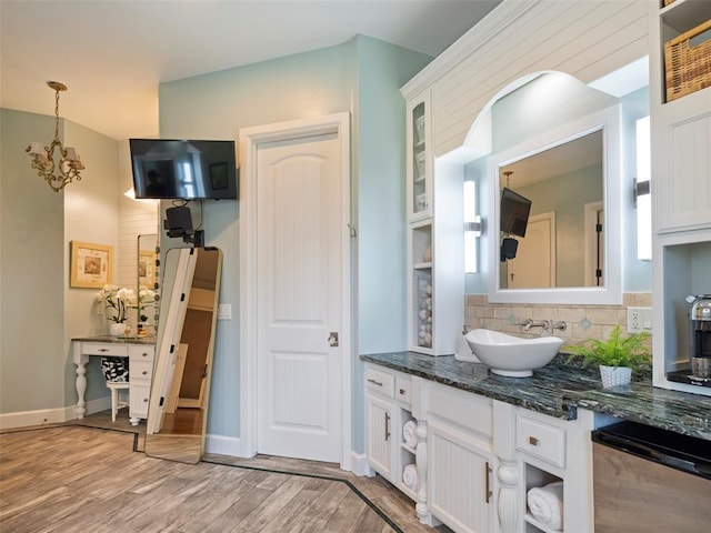 3325 Winding Creek Cir, Edmond, OK 73034 - bathroom featuring wood finished floors, a chandelier, decorative backsplash, and vanity