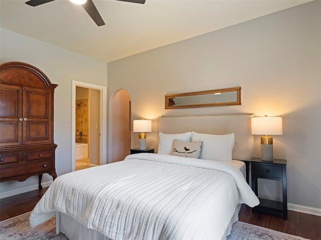 3325 Winding Creek Cir, Edmond, OK 73034 - bedroom with wood finished floors, arched walkways, a ceiling fan, and connected bathroom