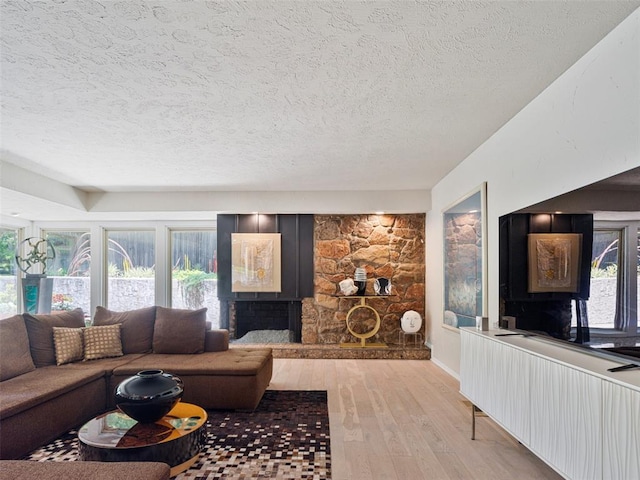 7501 Brookside Dr, Oklahoma City, OK 73132 - living area with a textured ceiling, light wood-type flooring, and a stone fireplace