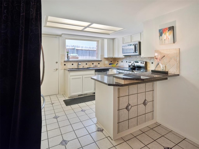 7501 Brookside Dr, Oklahoma City, OK 73132 - kitchen featuring appliances with stainless steel finishes, a peninsula, decorative backsplash, and light tile patterned flooring