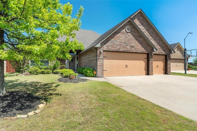 2828 Ryder Dr, Yukon, OK 73099 - view of front facade with an attached garage, concrete driveway, a front lawn, brick siding, and a shingled roof