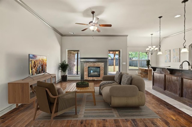 2828 Ryder Dr, Yukon, OK 73099 - living area with a brick fireplace, hardwood / wood-style floors, ceiling fan, crown molding, and a chandelier