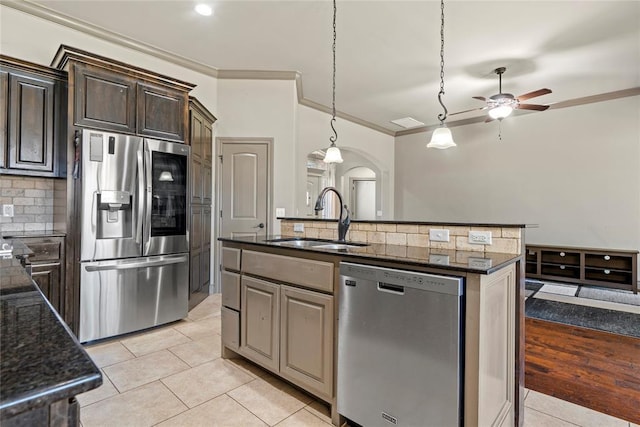 2828 Ryder Dr, Yukon, OK 73099 - kitchen featuring appliances with stainless steel finishes, arched walkways, a ceiling fan, tasteful backsplash, and light tile patterned floors