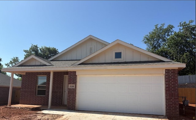 9100 SW 20th St, Oklahoma City, OK 73128 - ranch-style home with brick siding, board and batten siding, an attached garage, roof with shingles, and driveway