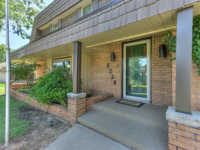 9220 Sutton Pl, Oklahoma City, OK 73132 - entrance to property featuring covered porch, mansard roof, and brick siding