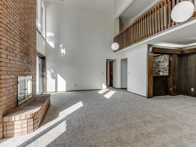 9220 Sutton Pl, Oklahoma City, OK 73132 - unfurnished living room with a towering ceiling, carpet flooring, and brick wall