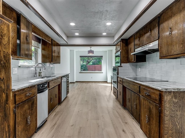 9220 Sutton Pl, Oklahoma City, OK 73132 - kitchen featuring under cabinet range hood, appliances with stainless steel finishes, light wood-style floors, dark brown cabinetry, and backsplash