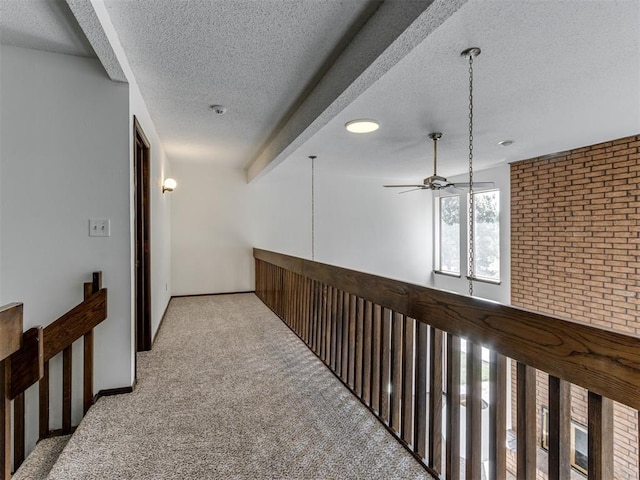 9220 Sutton Pl, Oklahoma City, OK 73132 - hallway featuring carpet floors, a textured ceiling, beam ceiling, brick wall, and an upstairs landing