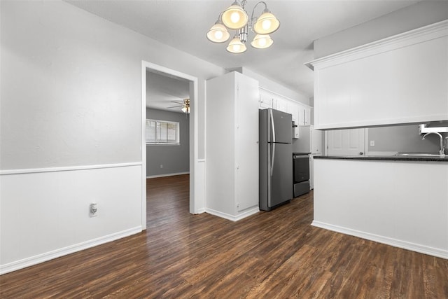 4101 NW 51st St, Oklahoma City, OK 73112 - kitchen featuring freestanding refrigerator, dark countertops, white cabinetry, a chandelier, and dark wood-style flooring