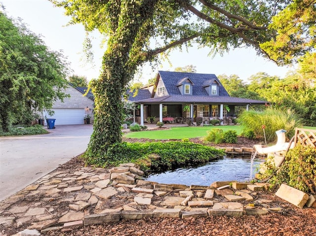 1301 E Rock Creek Rd, Tuttle, OK 73089 - view of front facade featuring a porch, a garden pond, a garage, driveway, and a shingled roof