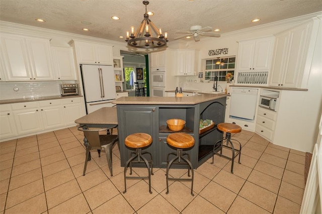 1301 E Rock Creek Rd, Tuttle, OK 73089 - kitchen featuring white appliances, open shelves, light tile patterned floors, white cabinets, and a chandelier