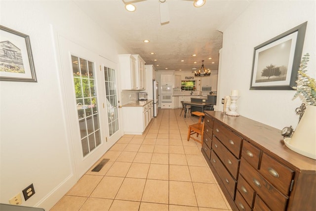1301 E Rock Creek Rd, Tuttle, OK 73089 - kitchen featuring freestanding refrigerator, light tile patterned floors, white cabinetry, a chandelier, and recessed lighting