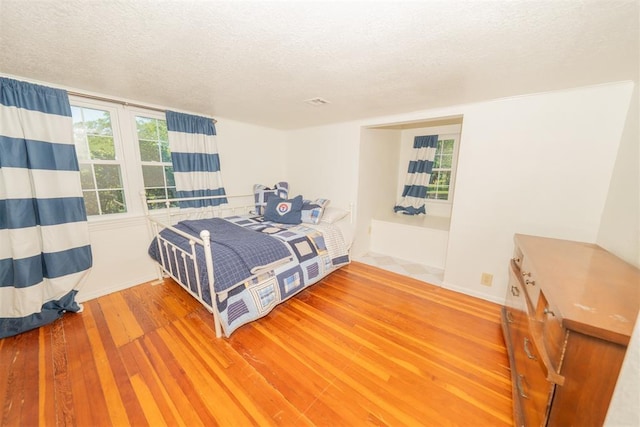 1301 E Rock Creek Rd, Tuttle, OK 73089 - bedroom with wood finished floors and a textured ceiling