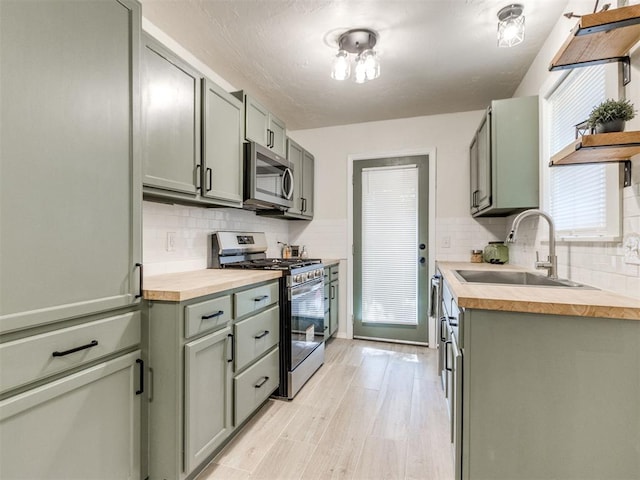 2753 SW 46th Pl, Oklahoma City, OK 73119 - kitchen featuring stainless steel appliances, butcher block counters, light wood-style floors, decorative backsplash, and green cabinets
