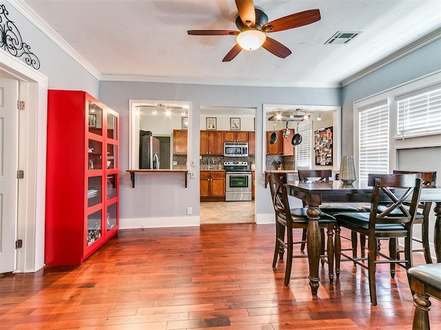 1122 NW 42nd St, Oklahoma City, OK 73118 - dining area featuring ceiling fan, wood-type flooring, and ornamental molding